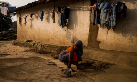 A woman preparing the floor of her village home in Hasdeo Arand