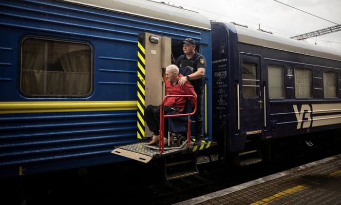 A police officer helps and older man to board a train to Dnipro and Lviv during an evacuation effort in Pokrovsk, Ukraine.