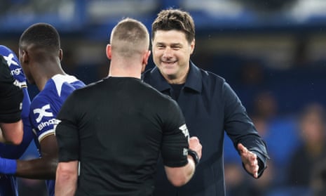 Mauricio Pochettino shakes the referee's hand and smiles after beating Tottenham