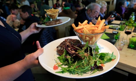 Steak frites being brought to a restaurant table in France