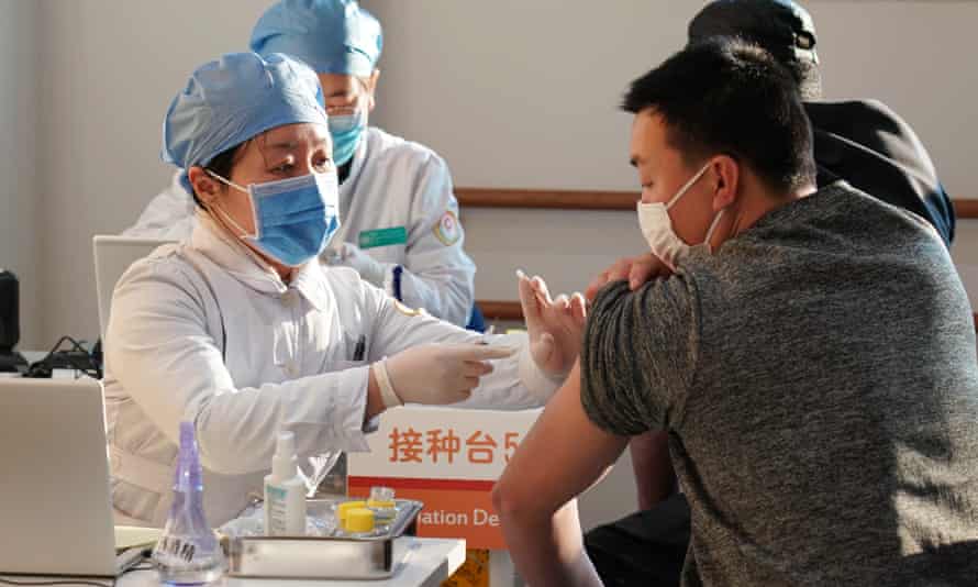 People are inoculated with a Covid vaccine at a healthcare centre in Beijing