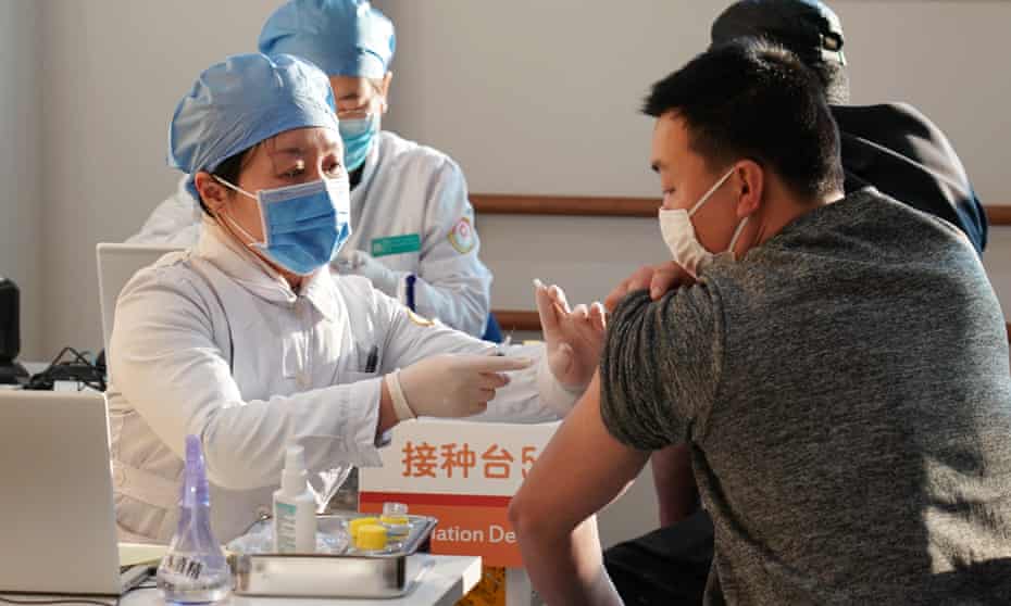 People are inoculated with a Covid vaccine at a health center in Beijing