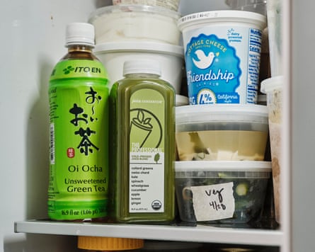 Inside of a fridge, with bottled green tea and cold pressed juice.