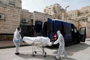 Ultra-Orthodox Jewish burial society workers with a coronavirus victim outside the Shamgar funeral house in Jerusalem.