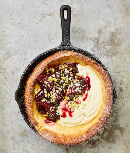 A cast-iron skiller with a puffy pancake, filled with fig preserve and sour cream.