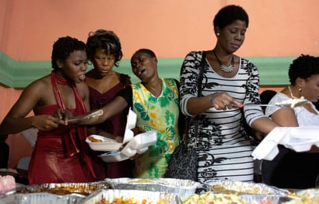 Guests squabble by the buffet table as they help themselves to food at Favilson Pierre and Mauseline Greffin’s wedding in Carrefour