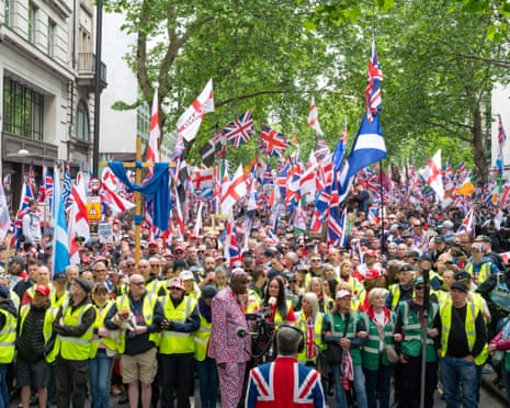 A large crowd at the front of the Unite the Kingdom rally wave various flags.