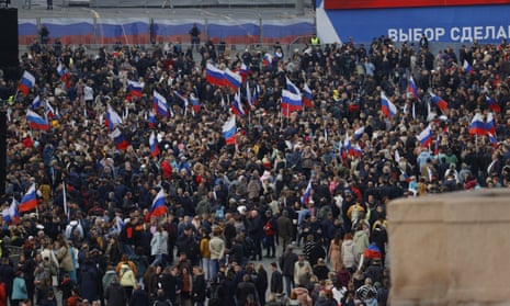 People holding Russian flags gather at Red Square during the annexation ceremony.