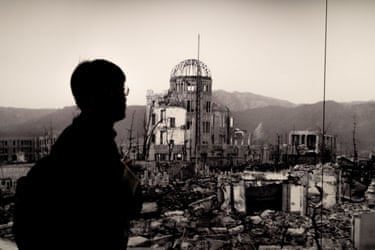 A visitor walks past a mural of the Atomic Bomb Dome