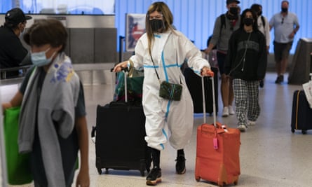 A traveler wearing a hazmat suit walks through the arrivals area at Los Angeles international airport on 30 November.