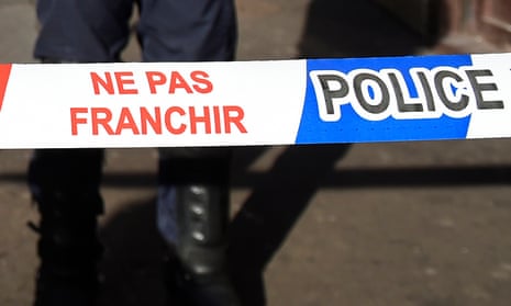 French police stand behind a police cordon.