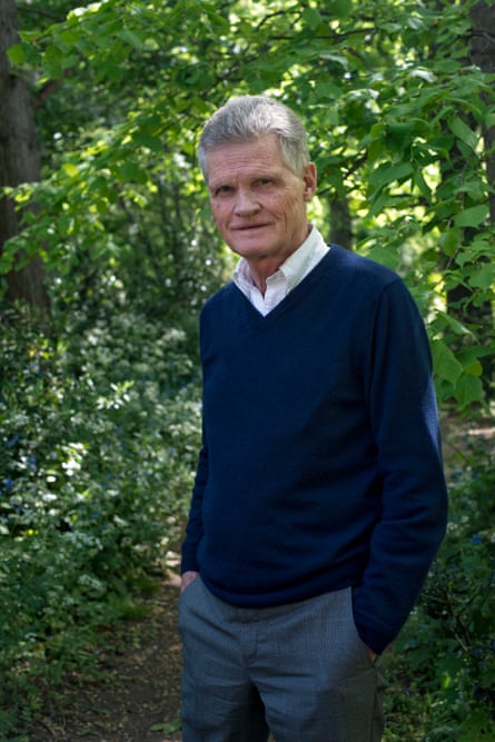 Prof Sir John Bell standing in front of trees