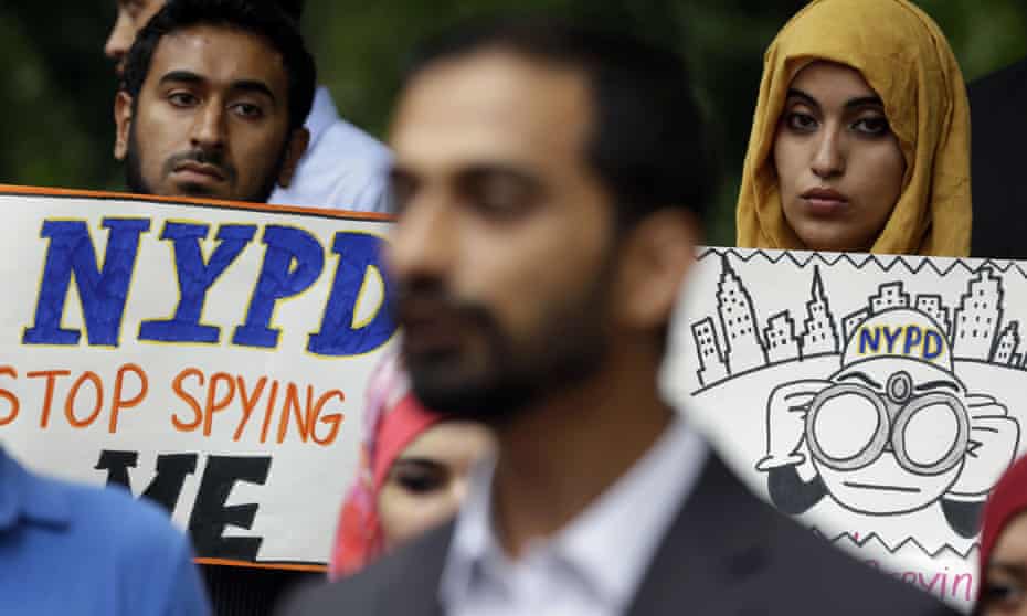 People hold signs at a rally to protest New York Police Department surveillance tactics near police headquarters in New York in August 2013. 