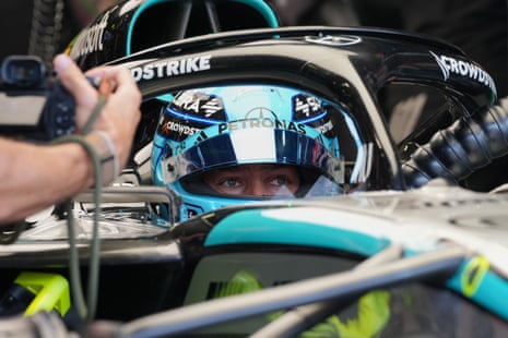 A close-up of George Russell in his car in his garage