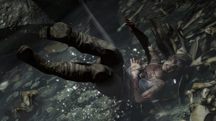 Lara Croft lies bloodied on rocks, reaching upward in dim light