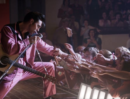 Scene from Elvis biopic depicting the singer performing as fans reach out to touch him