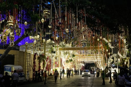 People walk past the Antilia mansion, house of billionaire Mukesh Ambani.