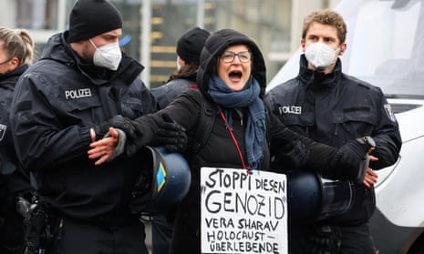 Police officers detain a woman wearing a banner reading ‘stop this genocide’ at a protest in front of the Reichstag building in Berlin, Germany.