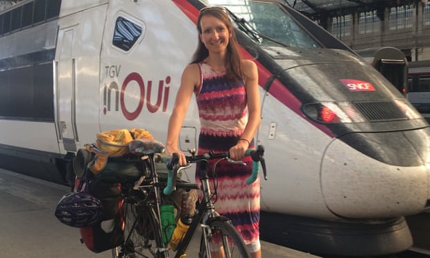 Anna Hughes with her heavily laden bike at the station, the front of a train behind