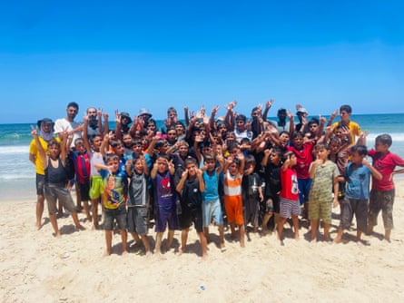 A big group of the children pose for a photo on the beach