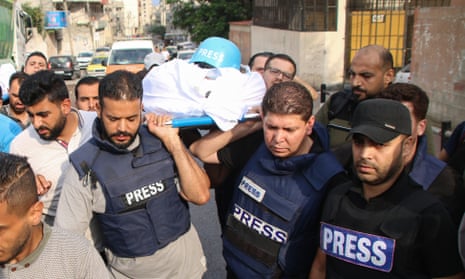 Friends and relatives carry the bodies of the Palestinian journalists Saeed al-Taweel and Mohammed Sobh.