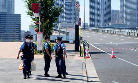 Police officers gather at the Olympic village, where a first positive Covid case was confirmed.