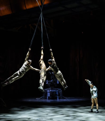 Three dancers holding ropes and swinging by one arm