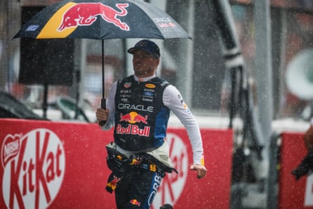 Max Verstappen holds a Red Bull umbrella