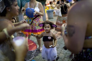 A young girl bangs on a drum during the block party