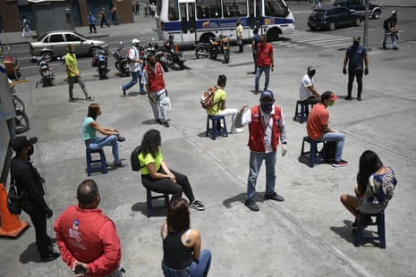 A worker from the Transportation Ministry explains proper mask usage to non-compliant pedestrians on a corner of downtown Caracas, Venezuela, on Monday, 29 June, 2020, amid efforts to contain the spread of coronavirus.