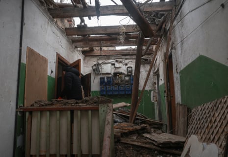 A resident looks at a flat in the apartment building hit by a drone.