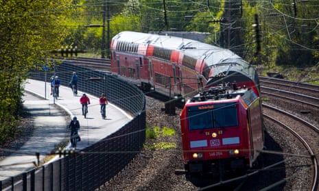 Commuters cycle beside a train on the new bicycle highway, RS1, that is set to span more than 60 miles in western Germany.
