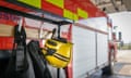 Firemans helmet hanging by fire engine in fire station<br>GettyImages-530022083