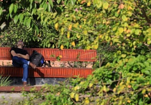 Man relaxes sat down on a bench at Parques del Rio in Medellín