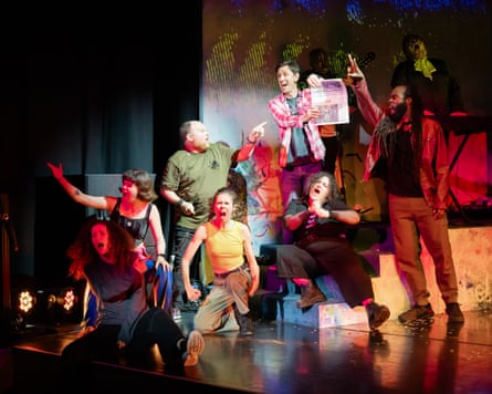 One performer in Perfect Show for Rachel holding the Guardian newspaper, the others on stage react