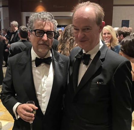 Kleber Mendonça Filho holds a drink while standing with Peter Bradshaw.