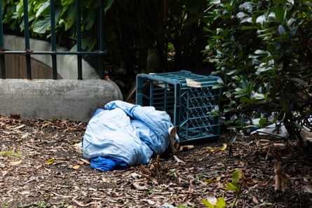 A rough sleeper’s belongings spill from an overturned milk crate