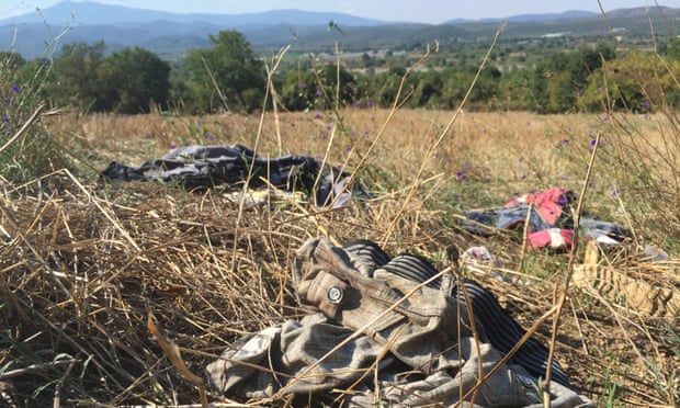 Clothes discarded by asylum seekers, a few metres from of Macedonia, which can be seen beyond the line of trees.