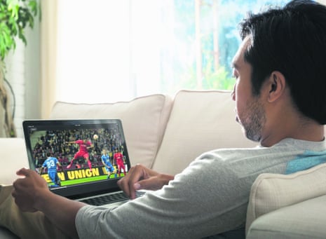man watching football on laptop