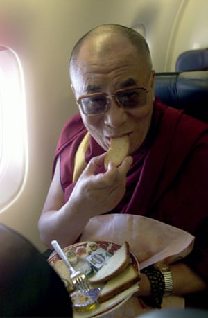 The Dalai Lama enjoys his breakfast on board of a Gandalf Airlines plane moments before landing at Orio al Serio airport in northern Italy in 1999.