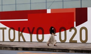 A woman walks past Tokyo 2020 sign in Tokyo today.
