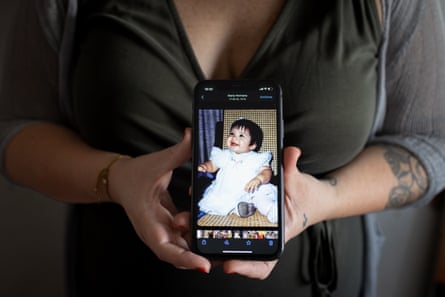 Maria holding a photograph of herself as a baby, before she was stolen from her birth mother in Chile