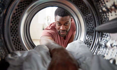 Posed by model View Looking Out From Inside Washing Machine As Man Does Laundry
