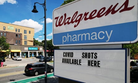 The red-on-white Walgreens logo on an outdoor sign, with letters spelling out “COVID shots available here.”