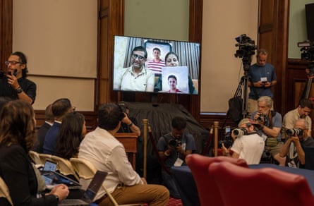 a man speaks through a video screen in a room