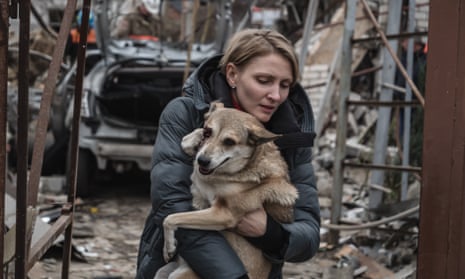 A local woman carries her wounded dog from the site of a Russian kamikaze drone strike on Mykolaiv, Ukraine.