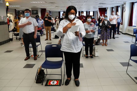 IIfeoma Eh, from Nigeria, stands with others wearing protective face masks during a US naturalisation ceremony in New York City on 22 July 2020.