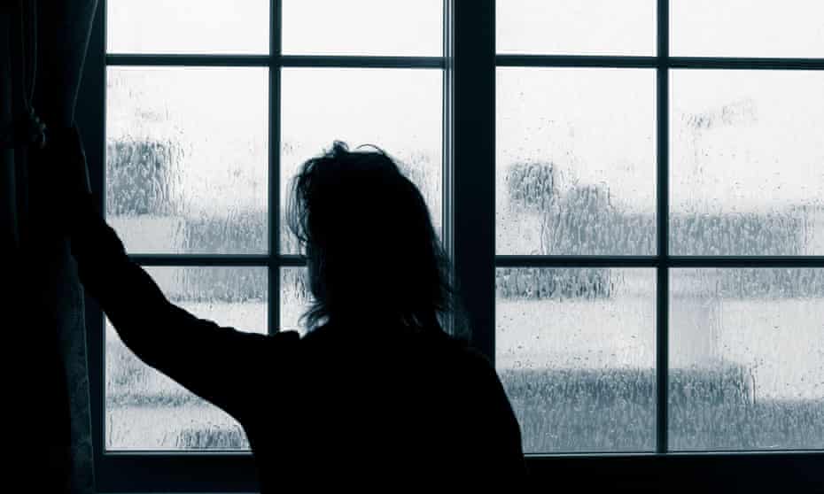 Woman looking out of window on rainy day. 