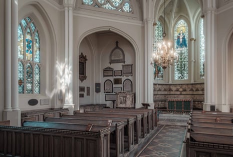 Interior of the church with pews, stained glass windows and a chandelier