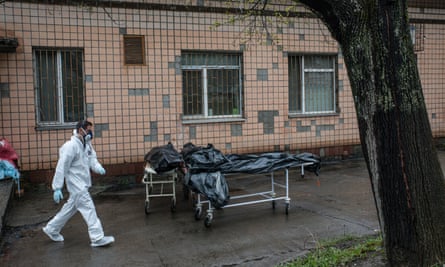 Experts from the forensic department of France’s national gendarmerie and Ukrainian doctors carrying bodies of civilians killed in Bucha.